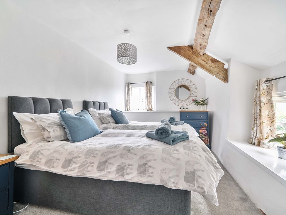 A bedroom with two beds and a mirror at 2 Pigsfoot Cottages Ash Thomas near Halberton, Devon