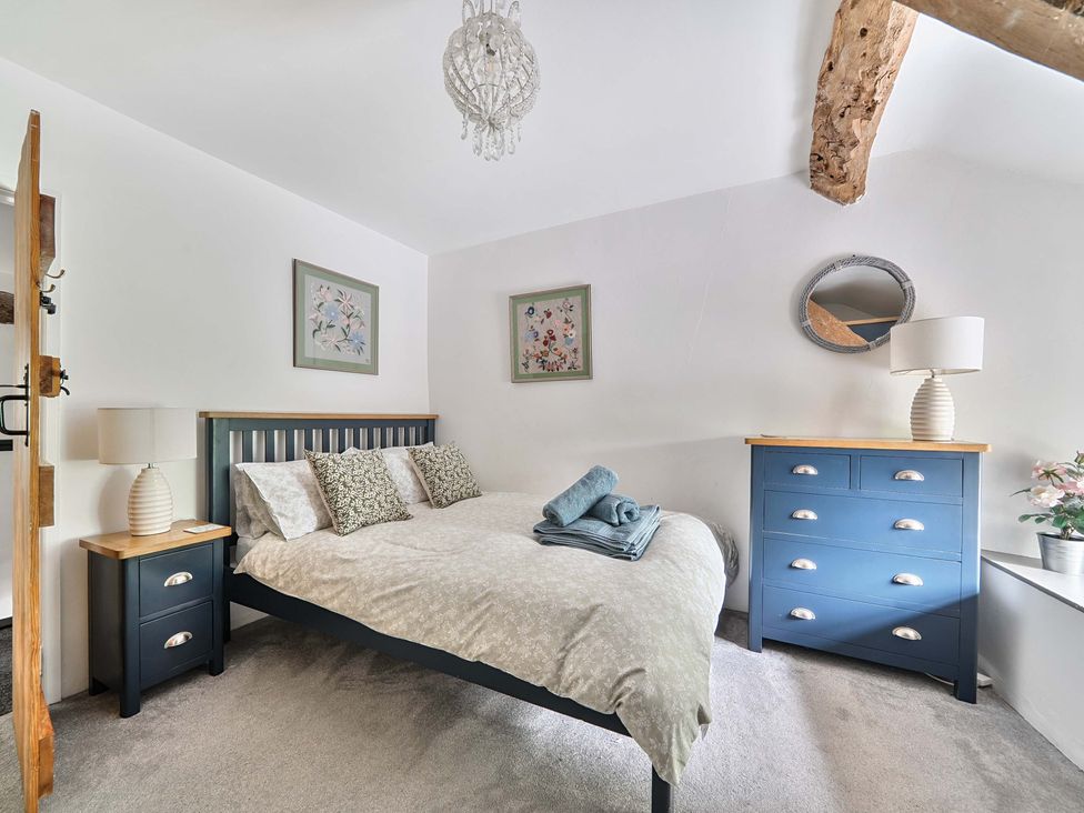 A bedroom with a bed and a nightstand at 2 Pigsfoot Cottages Ash Thomas near Halberton, Devon
