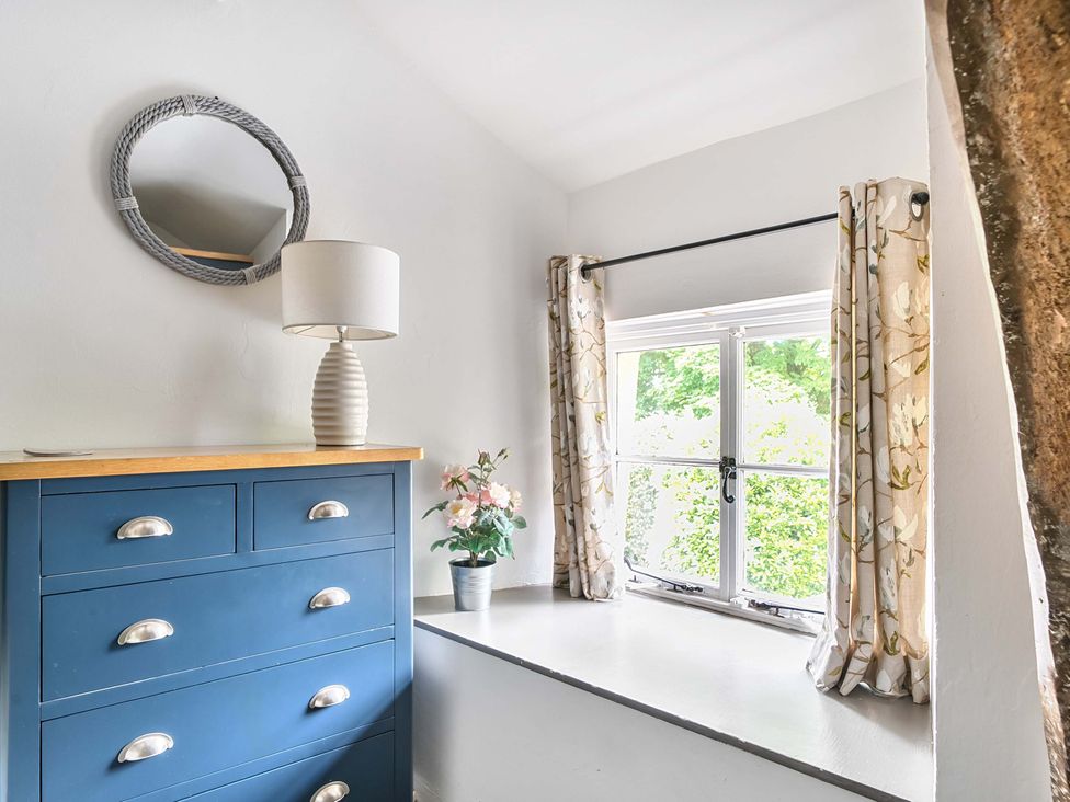 A bedroom with a chest of drawers and a mirror at 2 Pigsfoot Cottages near Halberton, Devon