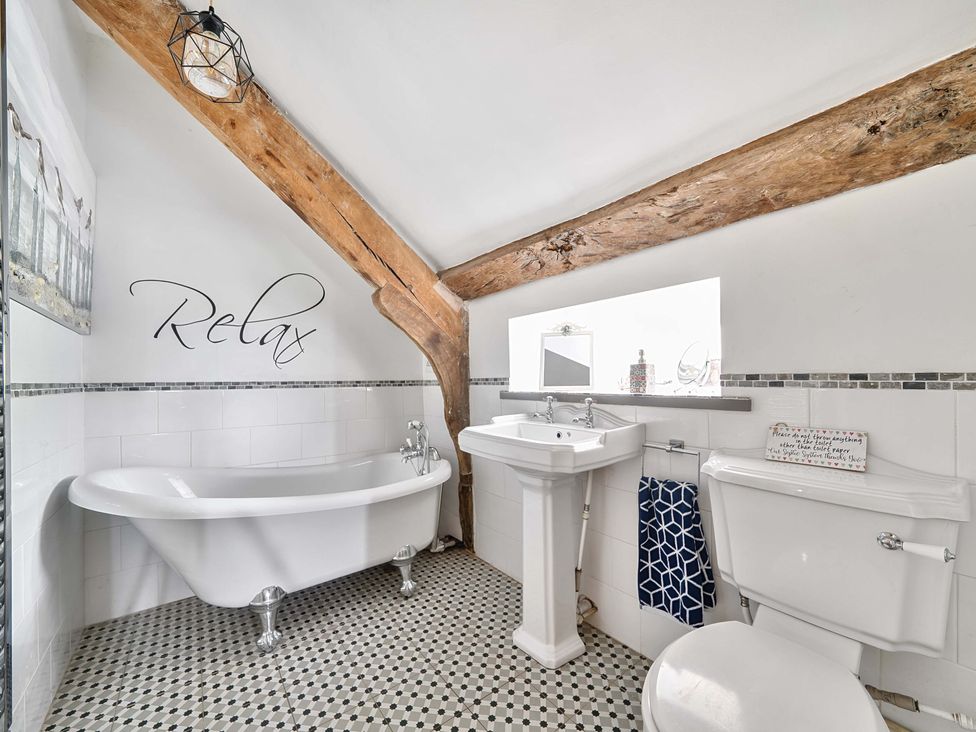 A bathroom with a bathtub, sink, and toilet at 2 Pigsfoot Cottages Ash Thomas near Halberton Devon