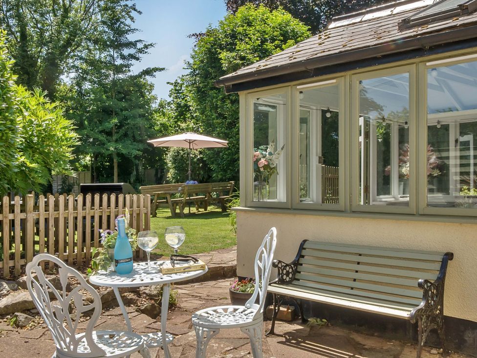 A garden with a table and chairs at 2 Pigsfoot Cottages Ash Thomas near Halberton, Devon
