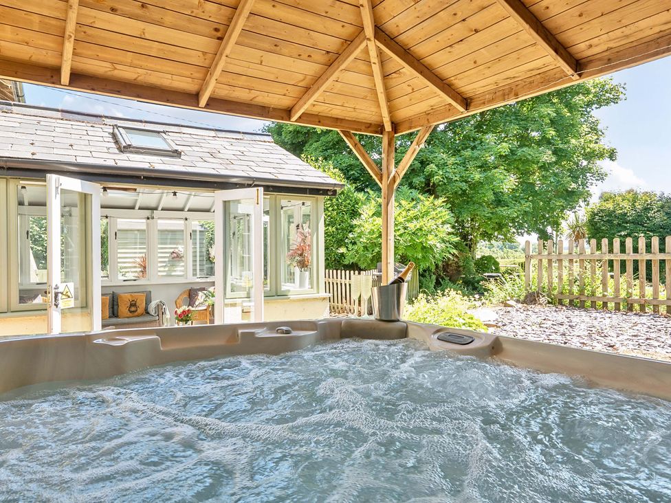 A hot tub with gazebo and surrounding garden at 2 Pigsfoot Cottages Ash Thomas near Halberton, Devon