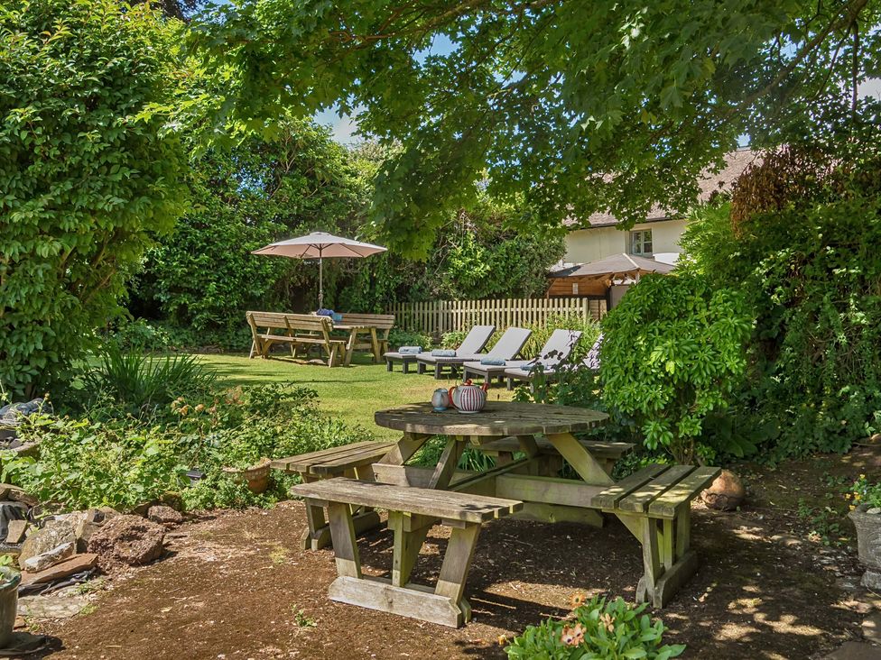 A garden with seating and plants at 2 Pigsfoot Cottages Ash Thomas near Halberton, Devon