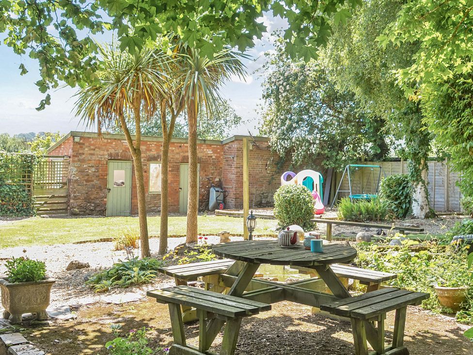 A garden with a table and chairs at 2 Pigsfoot Cottages Ash Thomas near Halberton, Devon