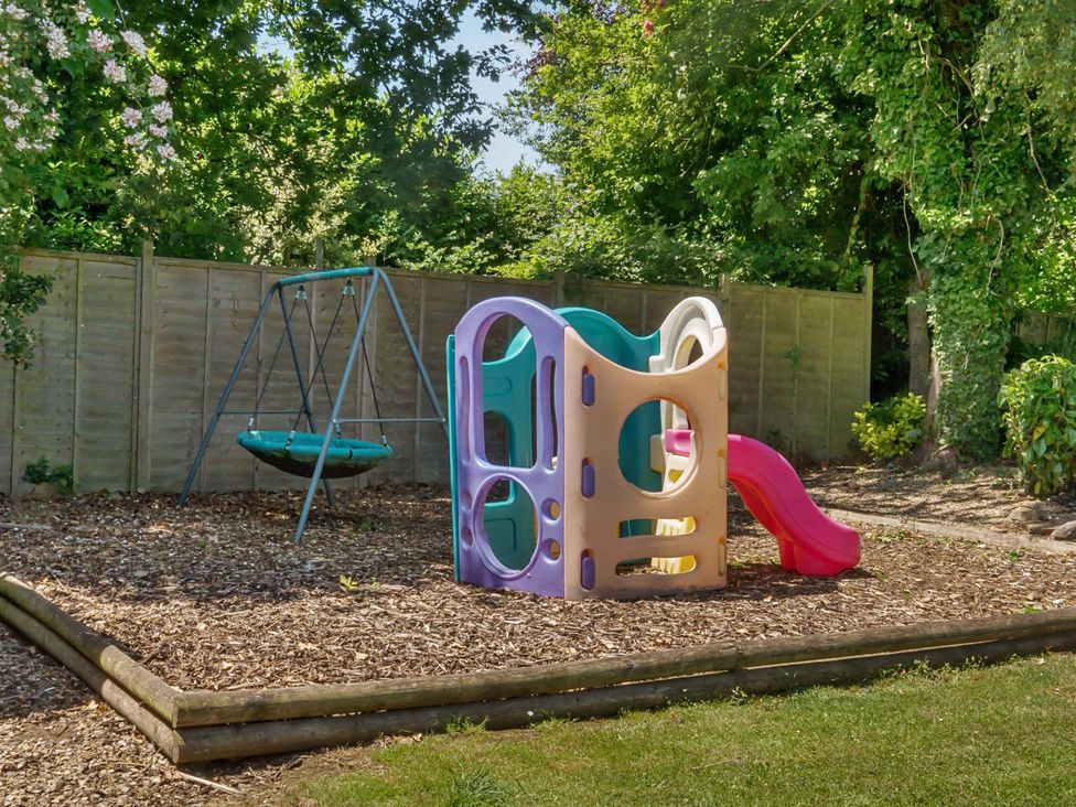 A playground with a slide and swing in a garden at 2 Pigsfoot Cottages Ash Thomas near Halberton, Devon