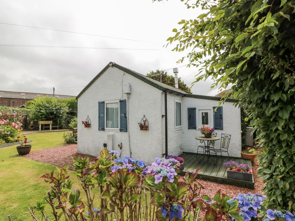 A cottage with garden furniture and flowers at Learig Cottage in Girvan