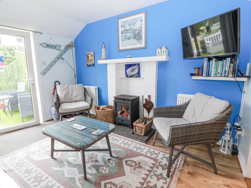 A living room with a fireplace and a television at Learig Cottage in Girvan