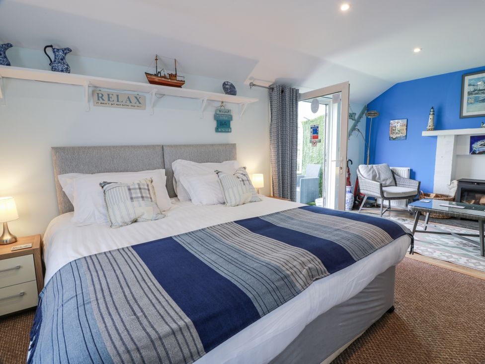 A bedroom with a bed and sitting area at Learig Cottage in Girvan