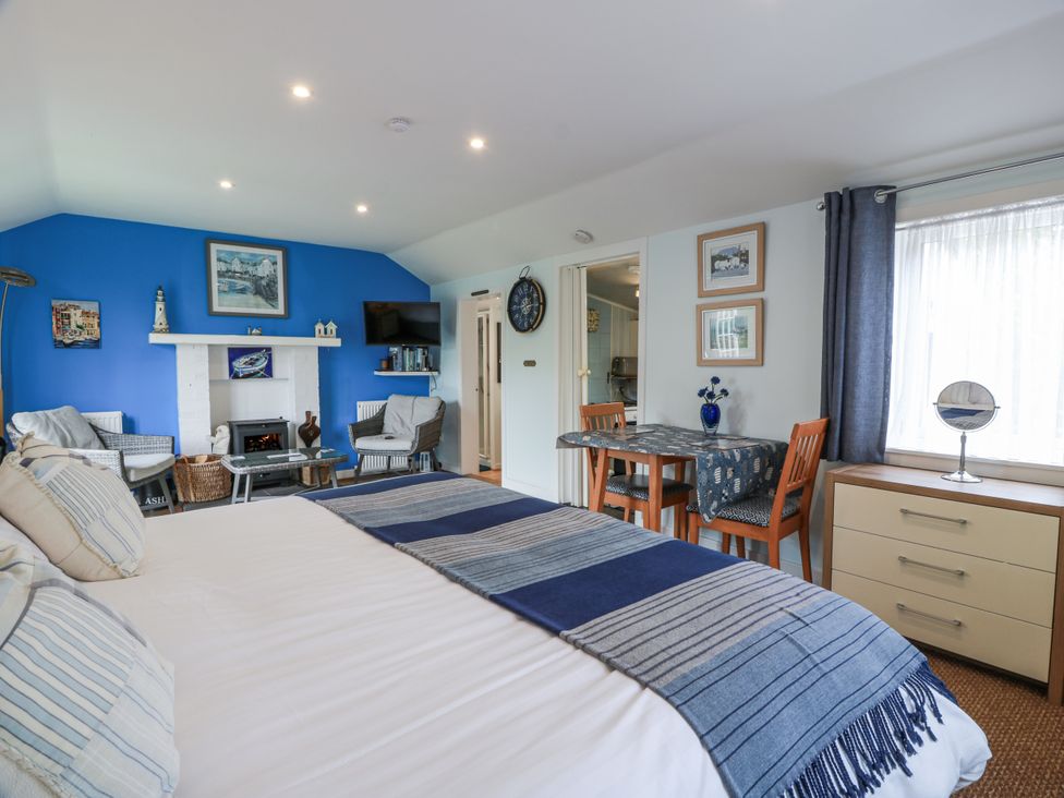 A bedroom with a bed and seating area at Learig Cottage in Girvan