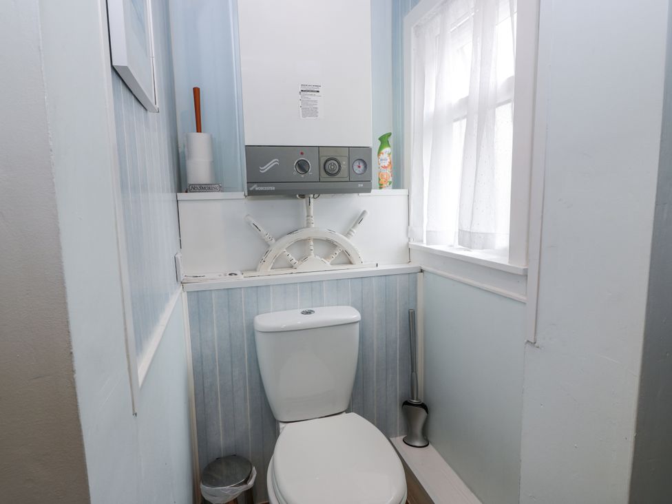 A bathroom with a toilet and boiler at Learig Cottage in Girvan
