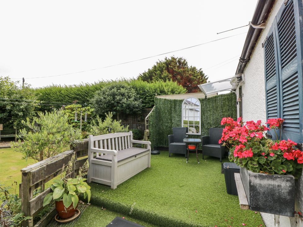 A garden area with a bench, chairs, and a table at Learig Cottage in Girvan