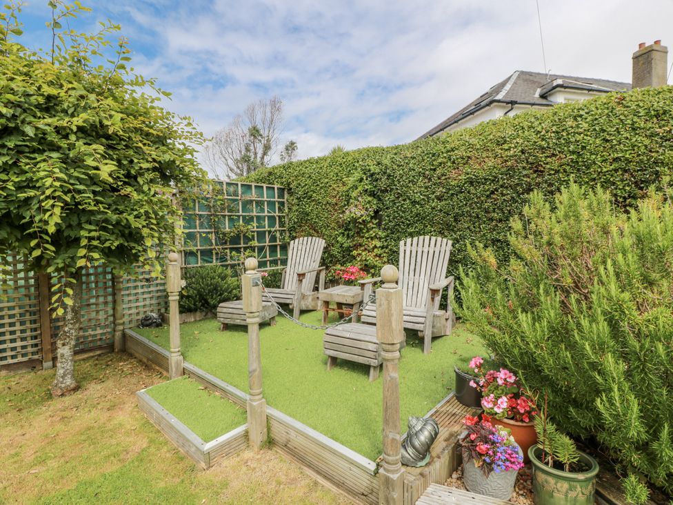 A garden with chairs and flowers at Learig Cottage in Girvan