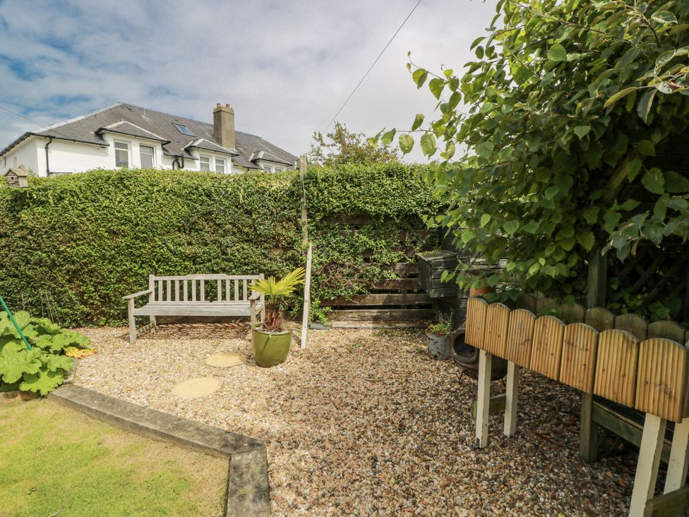 A garden with a bench and gravel at Learig Cottage in Girvan