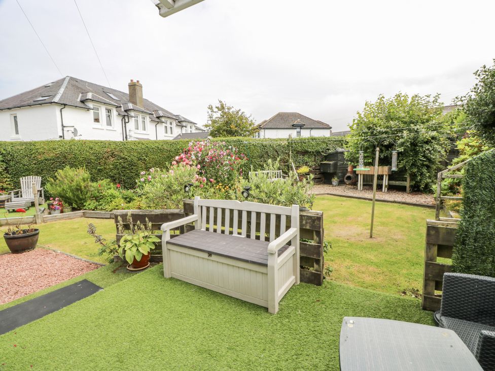 A garden with a bench and flowers at Learig Cottage in Girvan