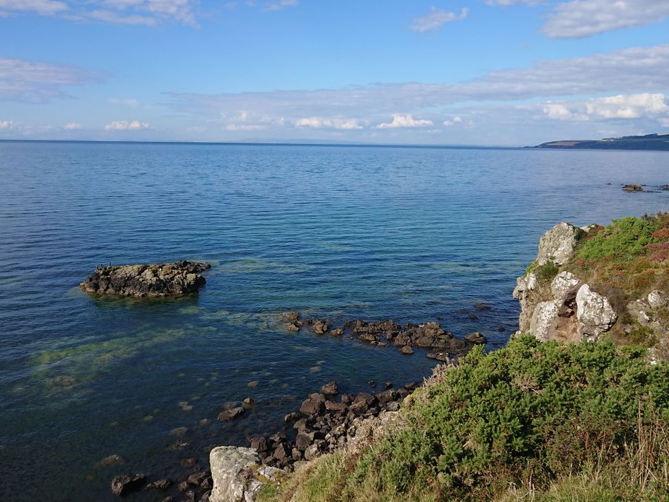 A coastal view with rocks and water at Learig Cottage in Girvan