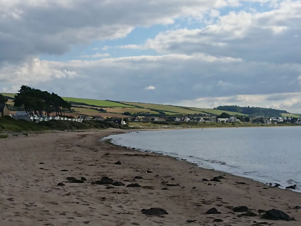 A beach with water and rocks at Learig Cottage in Girvan
