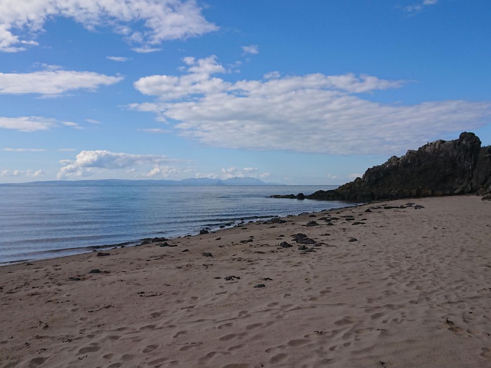A beach with sand and water at Learig Cottage in Girvan