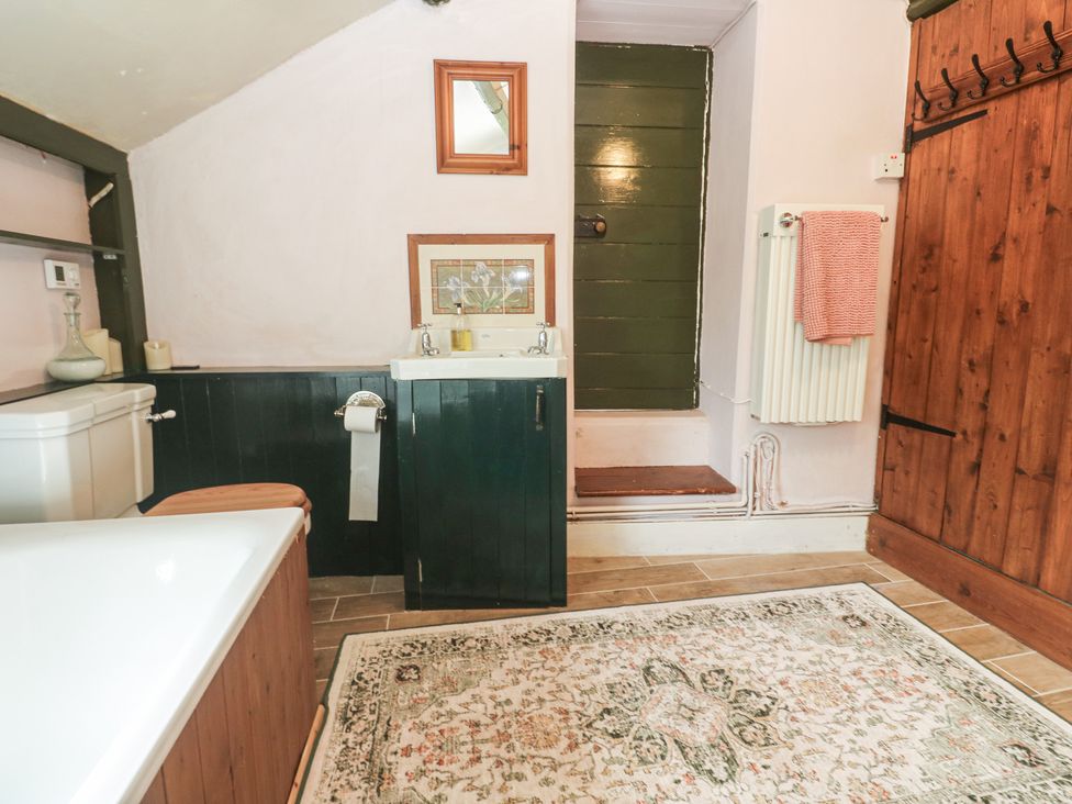 A bathroom with bathtub, toilet, sink, and towel rack at Pentira in Kuggar