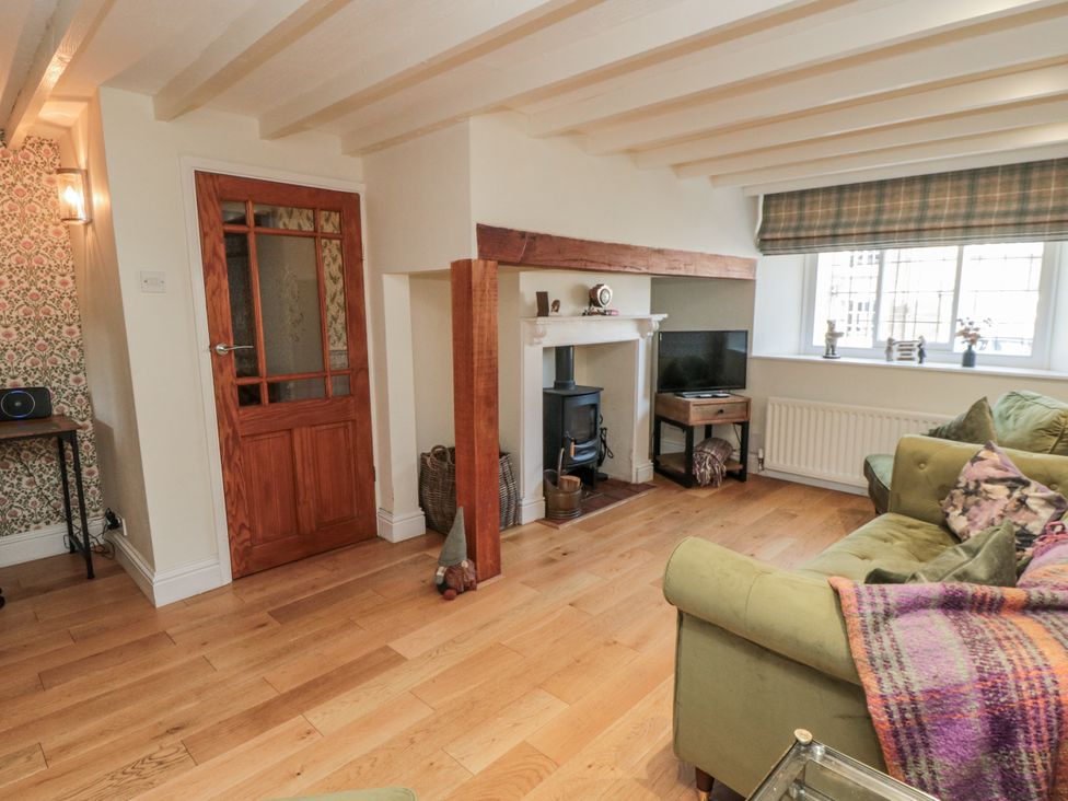 A living room with a sofa and fireplace at Inglenook Cottage in Guisborough
