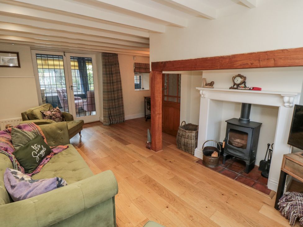 A living room with a wood stove and a sofa at Inglenook Cottage in Guisborough