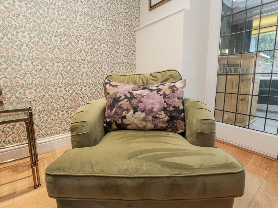 An armchair with a cushion in a sitting room at Inglenook Cottage in Guisborough