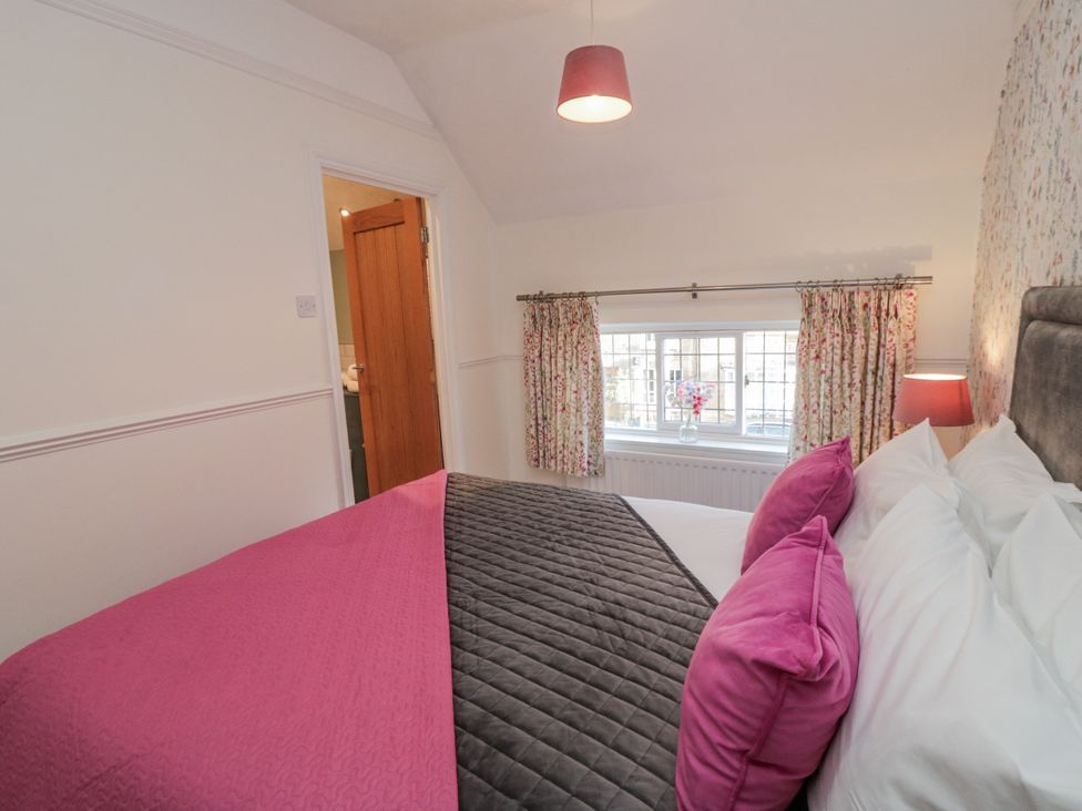 A bedroom with a bed and pillows at Inglenook Cottage Guisborough