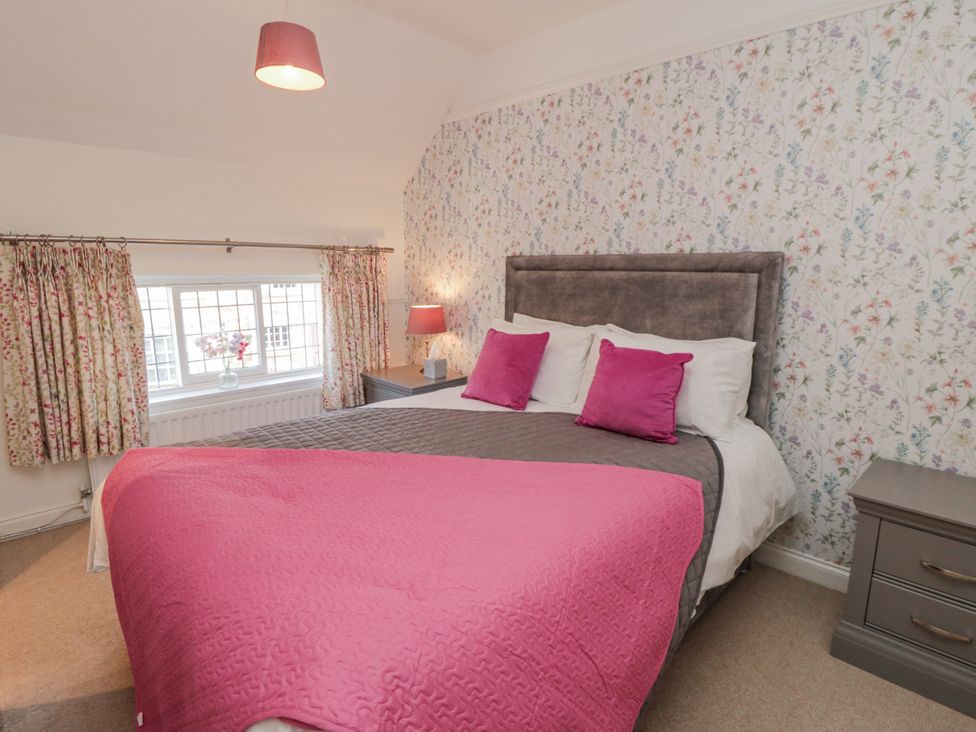 A bedroom with a bed and window at Inglenook Cottage Guisborough
