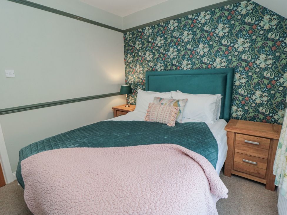 A bedroom with a bed and bedside table at Inglenook Cottage, Guisborough
