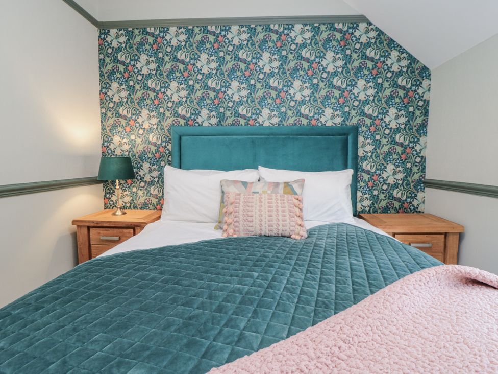 A bedroom with a bed and bedside table at Inglenook Cottage in Guisborough