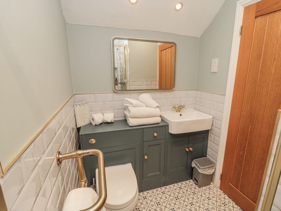 A bathroom with a sink and towels at Inglenook Cottage in Guisborough
