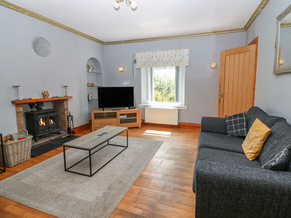 A living room with a fireplace and sofa at Rowan Cottage in Redcastle near Arbroath