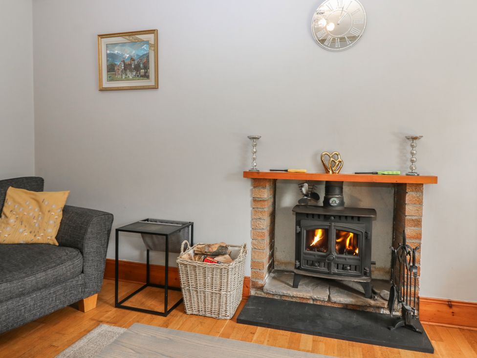 A living room with a fireplace and sofa at Rowan Cottage in Redcastle near Arbroath