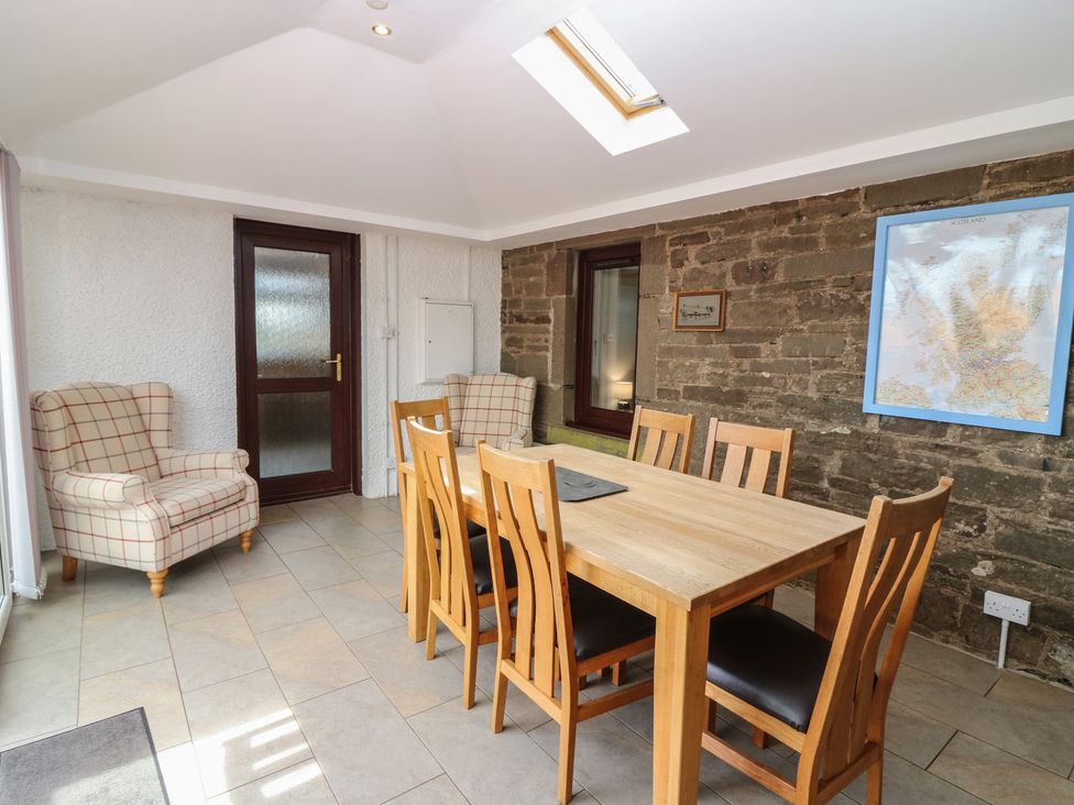 A dining room with a table and chairs at Rowan Cottage Redcastle near Arbroath
