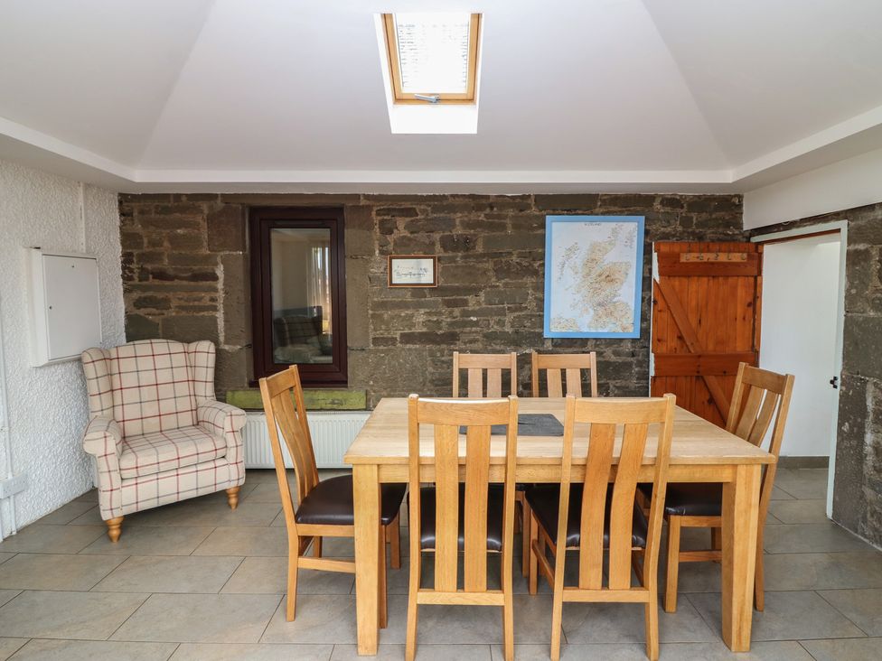 A dining room with a table and chairs at Rowan Cottage Redcastle near Arbroath