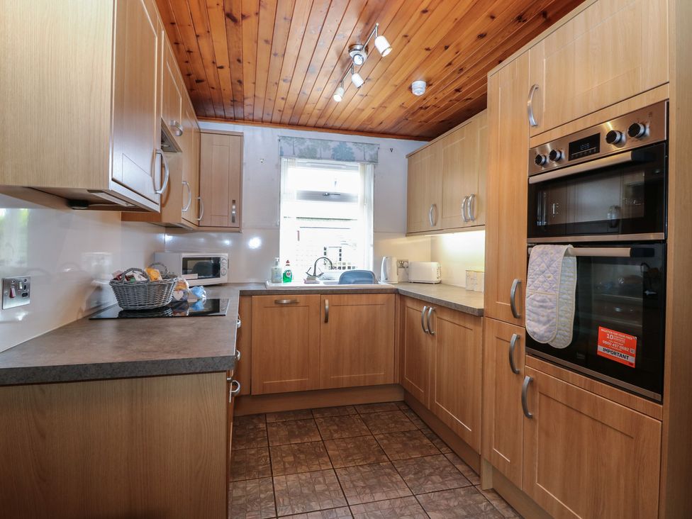 A kitchen with cabinets and appliances at Rowan Cottage Redcastle near Arbroath