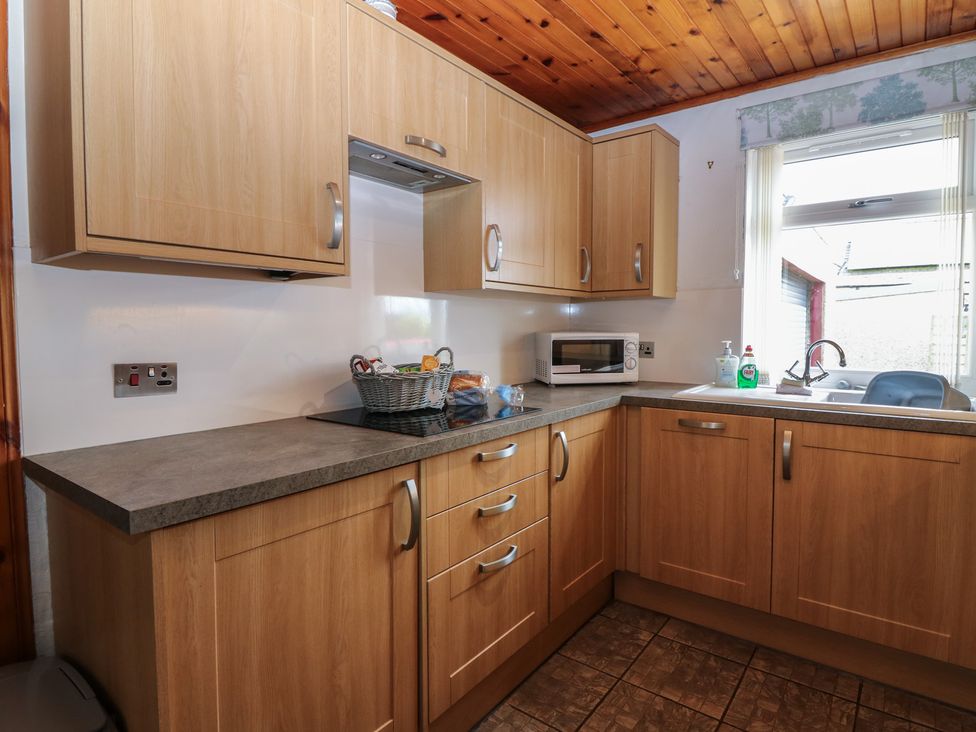 A kitchen with cabinets and appliances at Rowan Cottage Redcastle near Arbroath