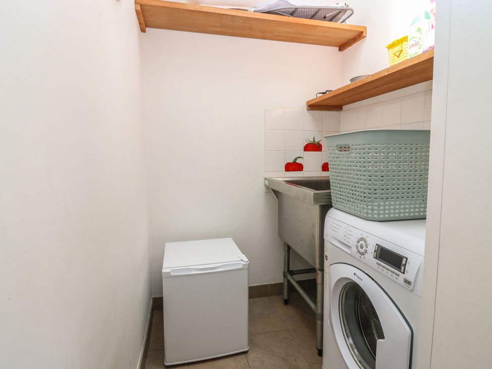 A laundry room with a washing machine and a sink at Rowan Cottage Redcastle near Arbroath