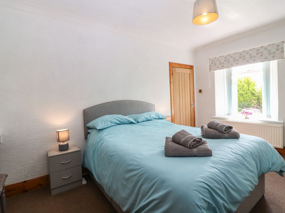 A bedroom with a bed and bedside table at Rowan Cottage in Redcastle near Arbroath