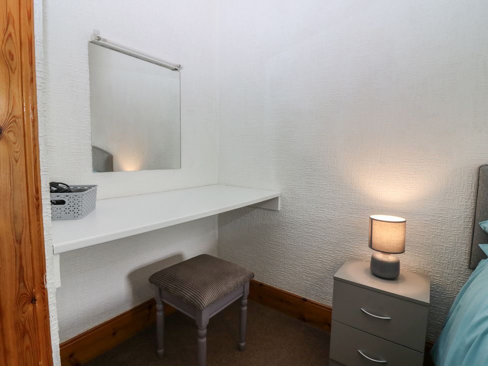 A bedroom with a desk and lamp at Rowan Cottage Redcastle near Arbroath