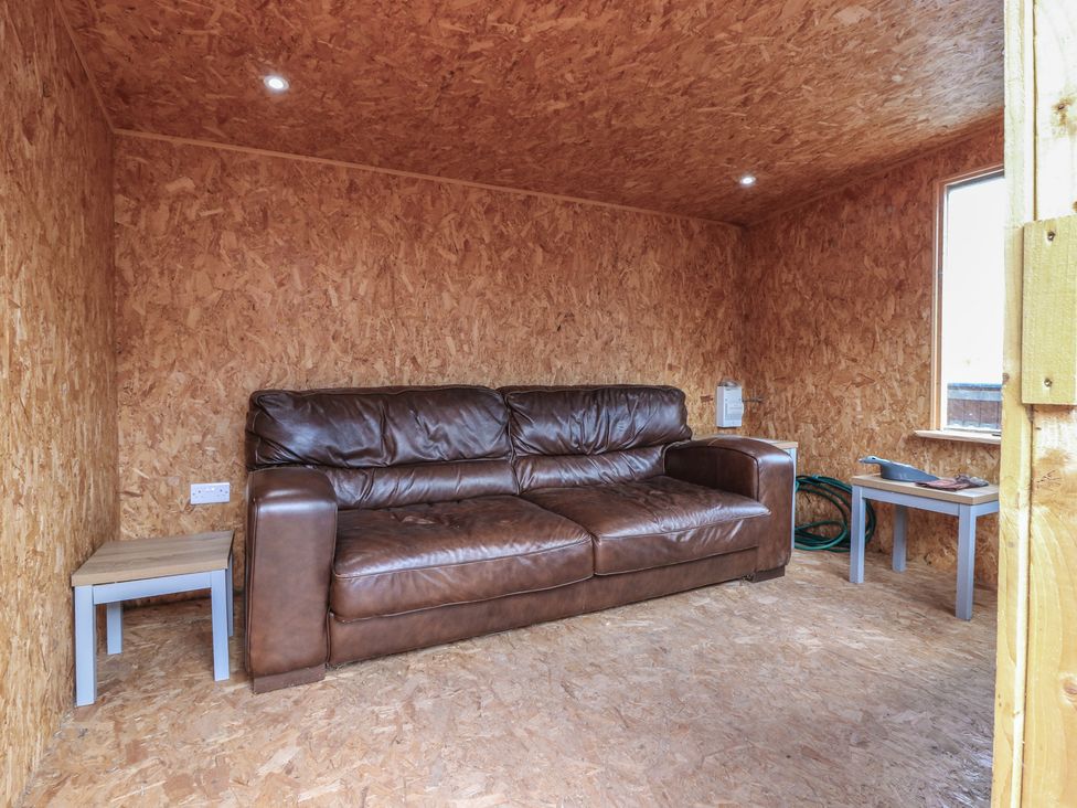 A snug with a sofa and side table at Rowan Cottage Redcastle near Arbroath