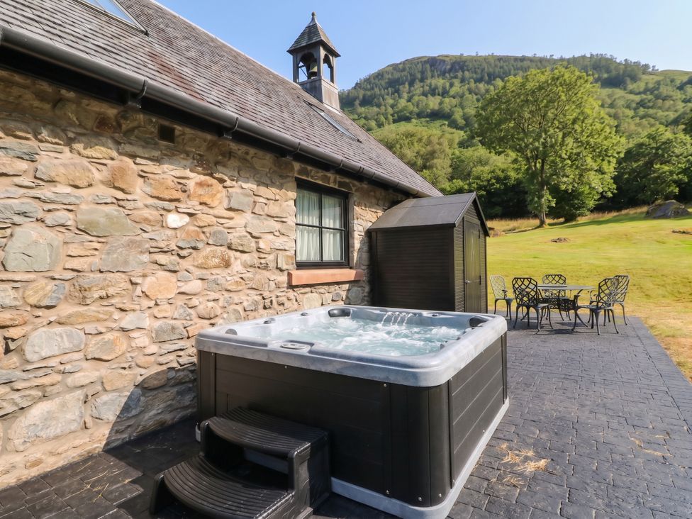 An outdoor area featuring a hot tub and garden furniture at Ardlui Church in Inverarnan near Crianlarich