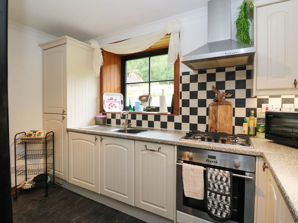 A kitchen with cabinets and appliances at Ardlui Church Inverarnan near Crianlarich