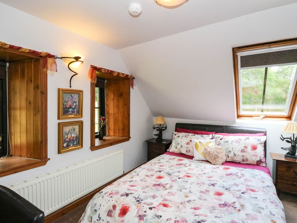 A bedroom with a bed and windows at Ardlui Church Inverarnan near Crianlarich
