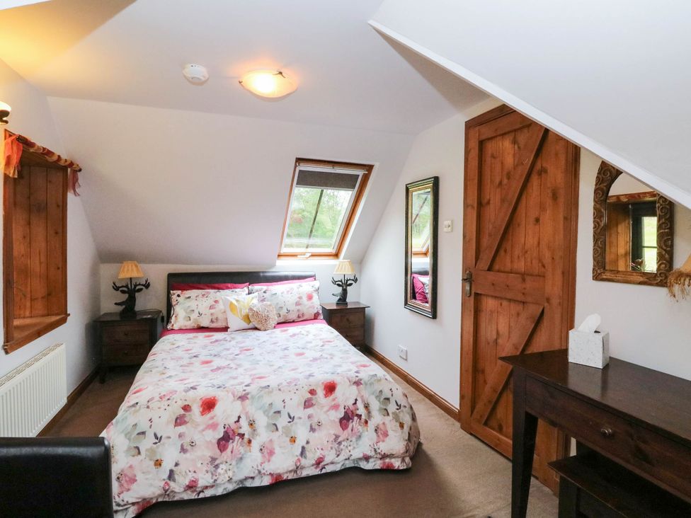 A bedroom with a bed and bedside tables at Ardlui Church in Inverarnan near Crianlarich
