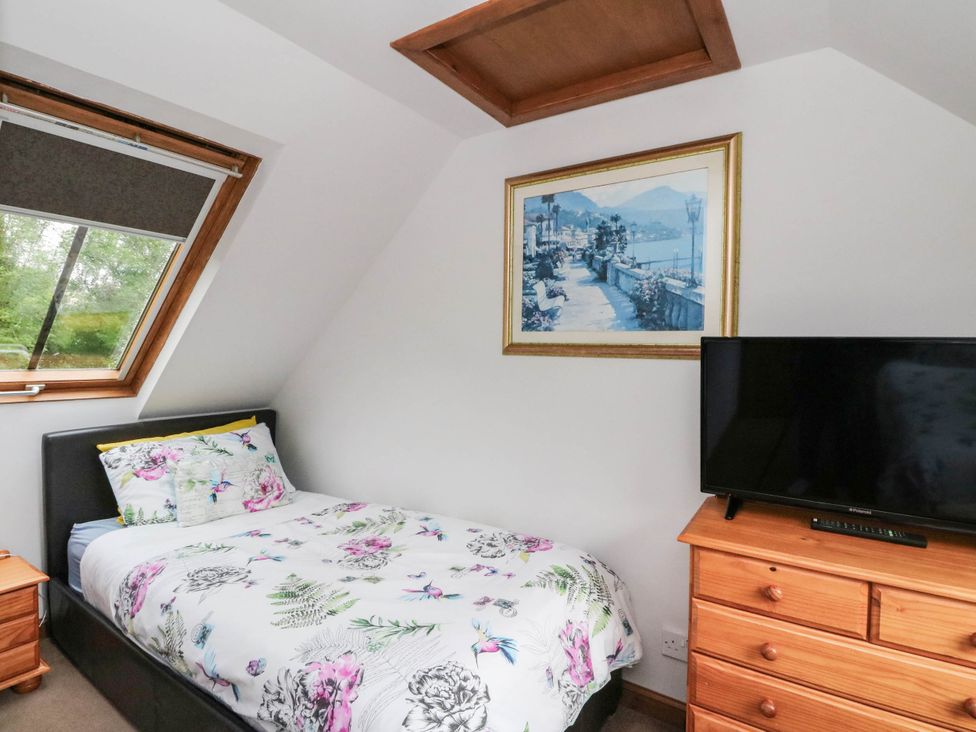 A bedroom with a bed and television at Ardlui Church in Inverarnan near Crianlarich