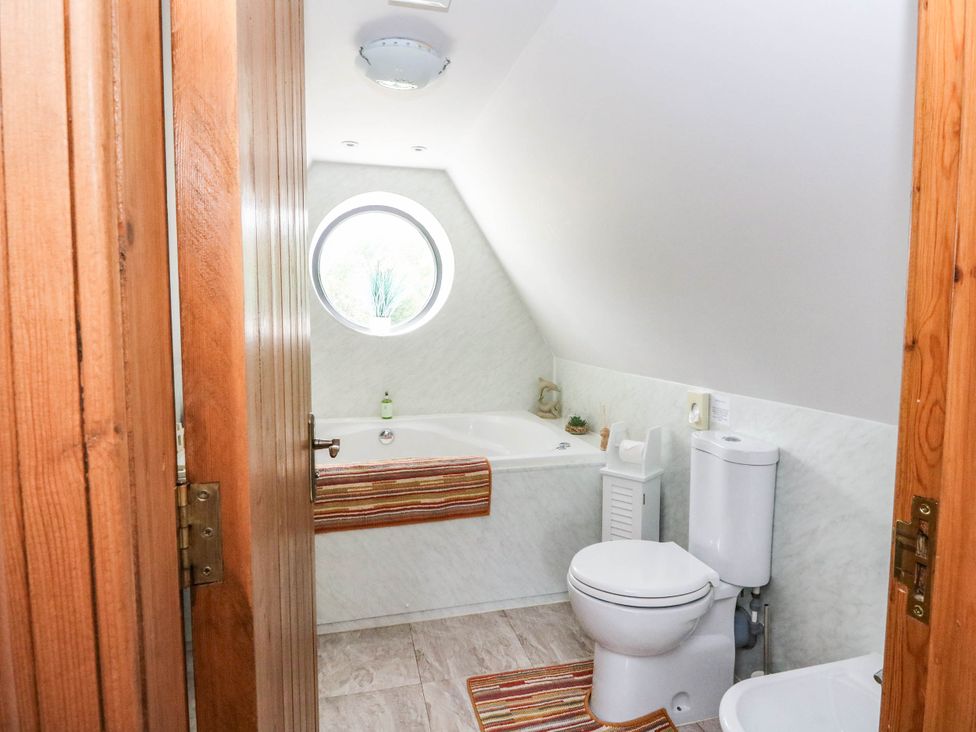 A bathroom with a bath tub and toilet at Ardlui Church in Inverarnan near Crianlarich