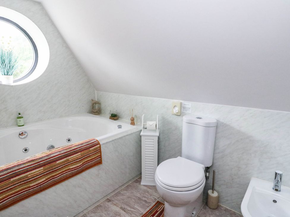 A bathroom with a bathtub and toilet at Ardlui Church in Inverarnan near Crianlarich