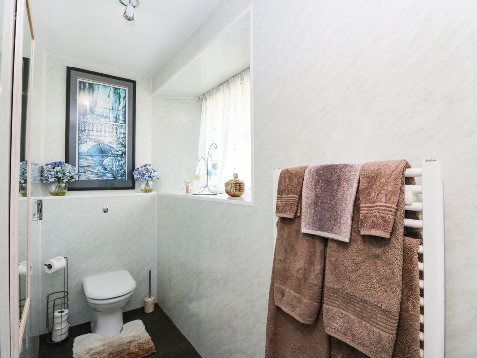 A bathroom with a toilet and towels on a rack at Ardlui Church in Inverarnan near Crianlarich