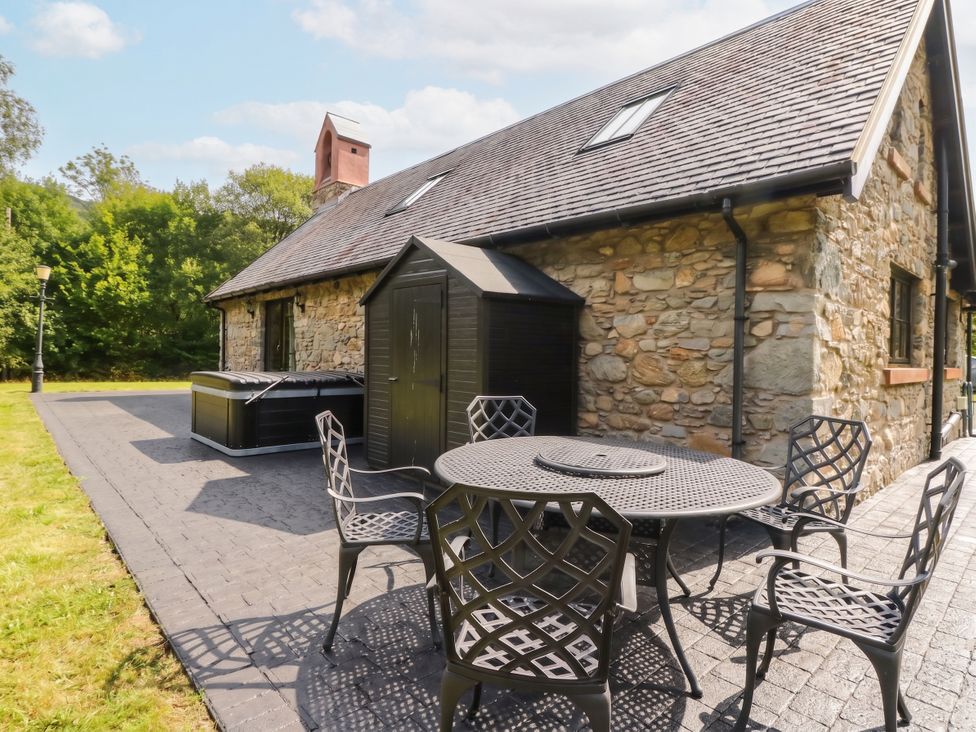An outdoor area with a table and chairs beside a hot tub at Ardlui Church in Inverarnan near Crianlarich