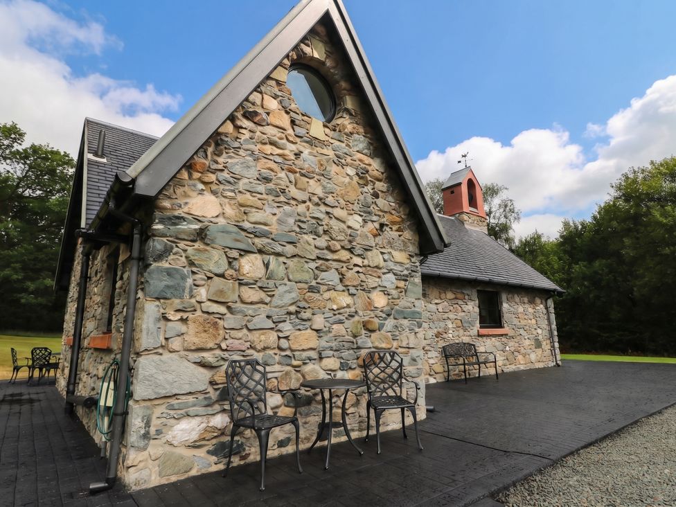 A stone building exterior with table and chairs at Ardlui Church Inverarnan near Crianlarich